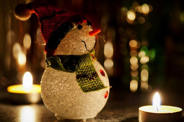 Muñeco de nieve de Navidad a la luz de las velas