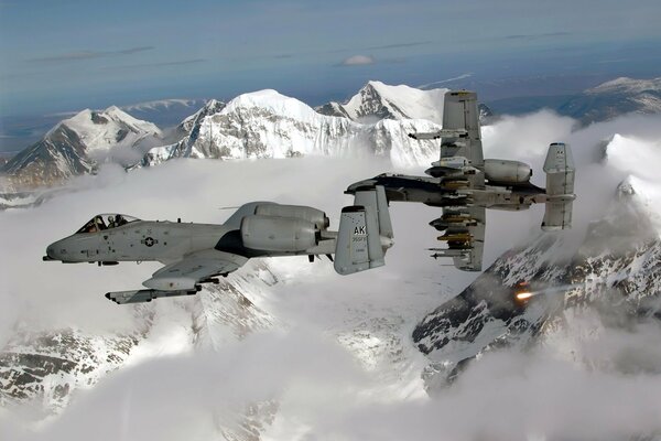 The plane flies over the mountains with snow