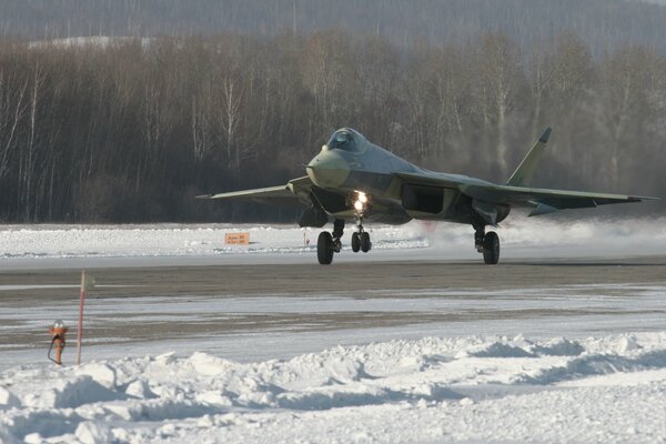 A fighter jet is preparing to take off on a snowy strip