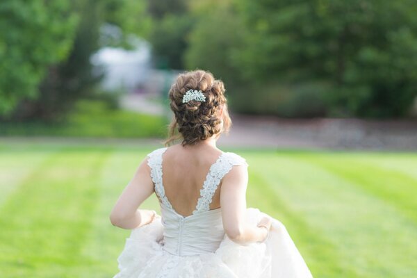 Mädchen im Hochzeitskleid auf dem Rasen