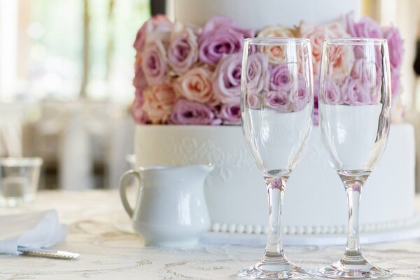 Torta nuziale con rose e due bicchieri