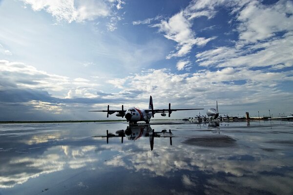 The plane is reflected in the mirror surface of the lake