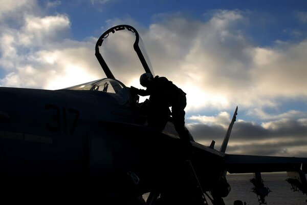 The pilot sits in the cockpit of the aircraft in cloudy weather