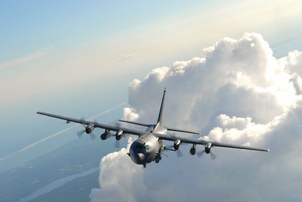 The plane is flying in the sky above the clouds