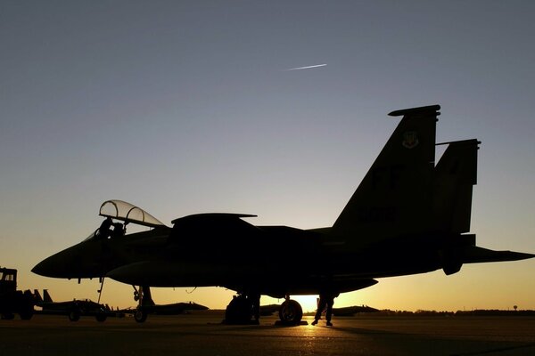 The fighter is at the airfield at dusk