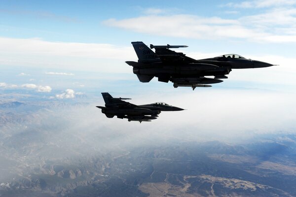 A pair of f-16s in the blue sky