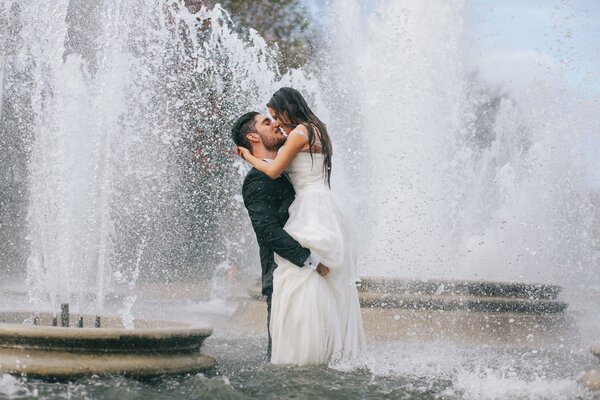 Mariée et le marié dans la fontaine. La joie du moment