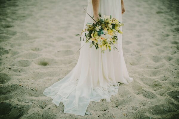 Bride with a bright bouquet on the beach