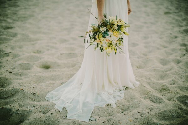 Mariée avec un bouquet lumineux sur la plage