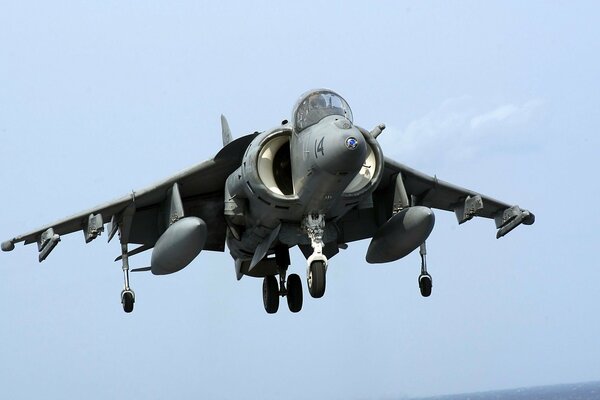 A Harrier fighter comes in to land on the deck of an aircraft carrier