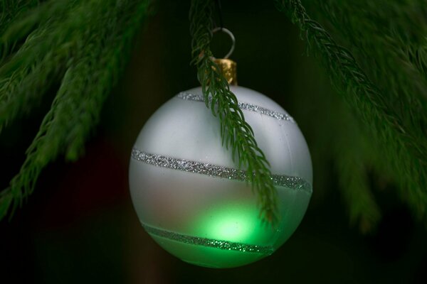 Jouet de Noël argent sur fond d arbre de Noël