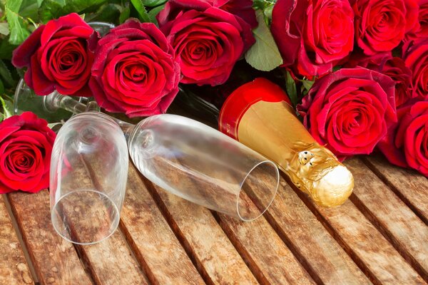 Bicchiere con una bottiglia di champagne e rose rosse