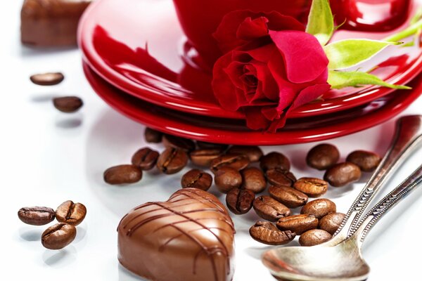 Cuore di cioccolato accanto a una rosa rossa su un piatto rosso