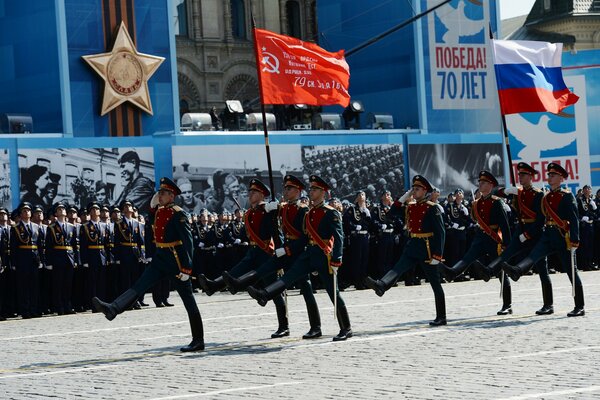 Московский парад ко дню победы. Солдаты с флагами маршируют по красной площади