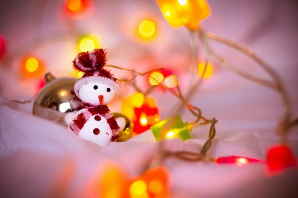 Spielzeug-Schneemann in Lichtern zu Weihnachten