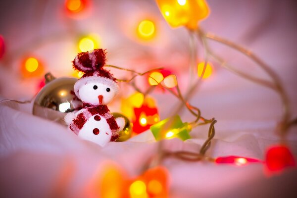 Pupazzo di neve giocattolo nelle luci per Natale