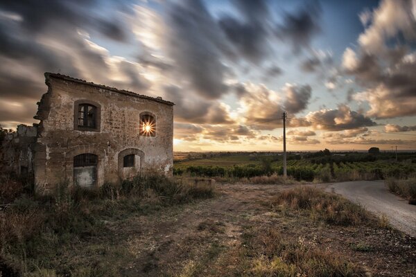 A house in a field at sunset