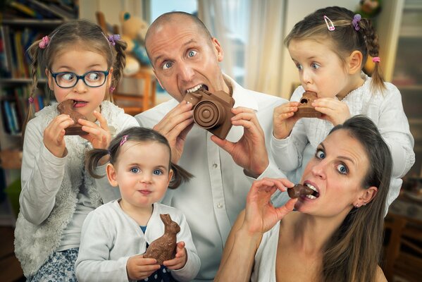 Семья в праздник святой Пасхи все вместе едят праздничный шоколад