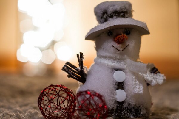 Muñeco de nieve con sombrero y dos bolas decorativas rojas