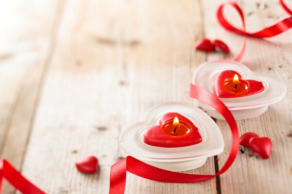 Velas encendidas en forma de corazones rojos