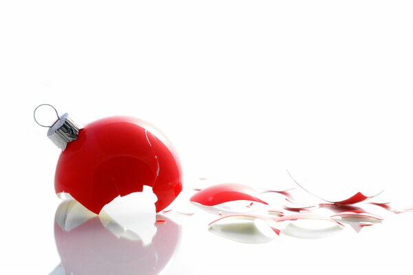 A broken red Christmas tree toy on a white background