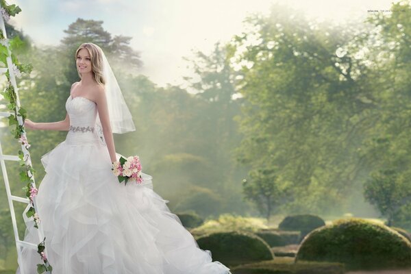 Smiling bride with a bouquet in nature