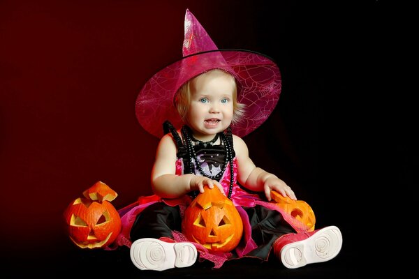 A child in a Halloween costume with pumpkins