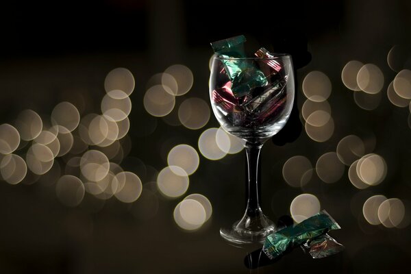 Verre de vin avec des bonbons sur la table de fête