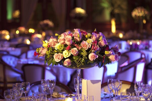 A celebration in a restaurant with a bouquet of roses