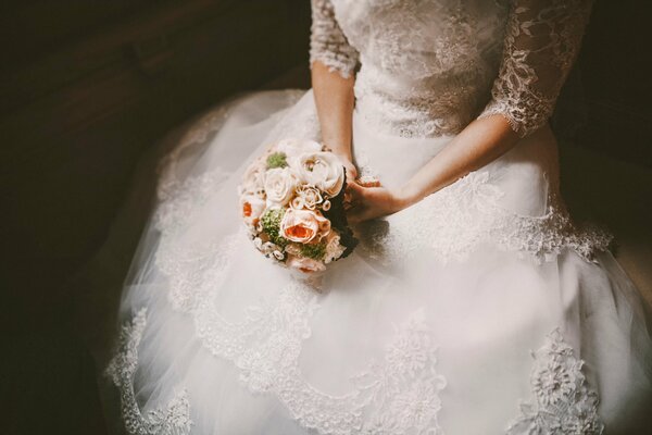 La mariée tient son bouquet assis seul