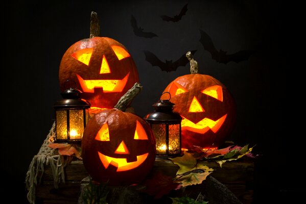 Calabaza con linternas y hojas de otoño en la mesa