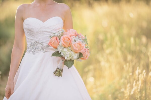 Foto del matrimonio. Sposa con bouquet. Foto nel campo