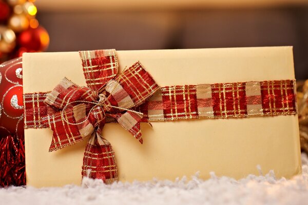 A postcard decorated with a red and gold ribbon tied in a bow for New Year or Christmas