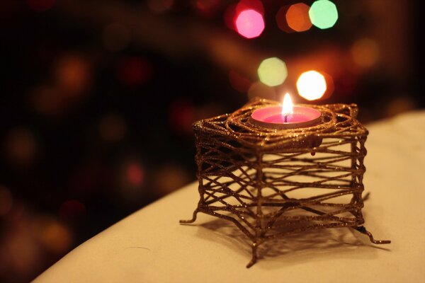 Una pequeña vela en un candelabro de mimbre