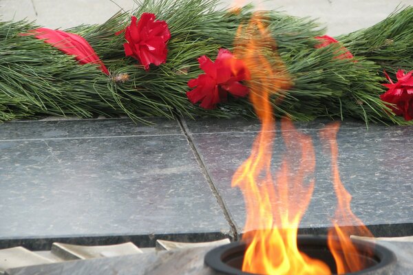 Fleurs à la mémoire des morts de la guerre près de la flamme éternelle