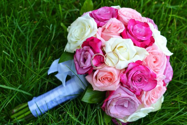 Ein Hochzeitsstrauß aus Rosen, der auf dem Gras liegt