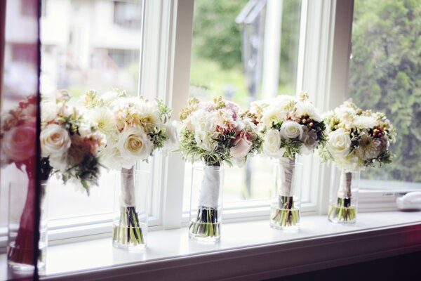 Delicate bouquets in vases on the windowsill