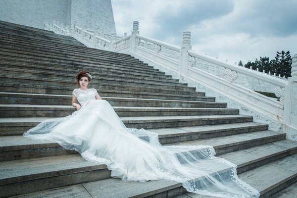 Foto der Braut auf der Treppe. Hochzeitskleid