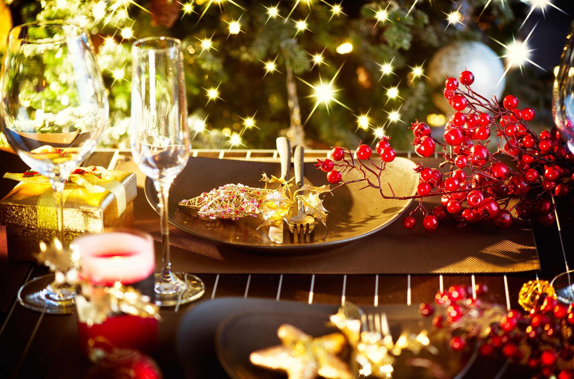 table festif verres à vin bougies assiettes vaisselle couverts étoile baies rouge houx hiver cadeaux nouvel an noël