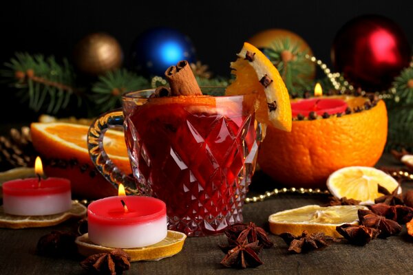 Decoración de la habitación con ramas de agujas de pino con piezas de naranja con velas y vino caliente