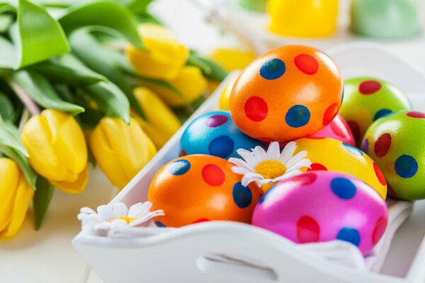 Bunte Ostereier mit Tulpen auf dem Tisch