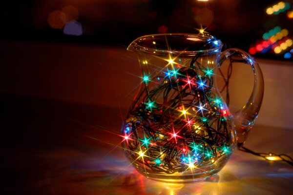 The bright lights of the garland shine in a glass jug and set the New Year mood