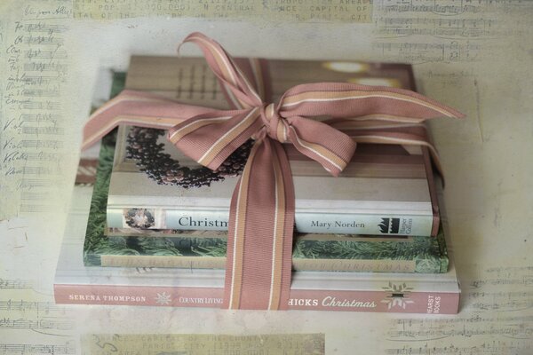 New Year s texture. Books tied with a pink bow on the background of vintage notes