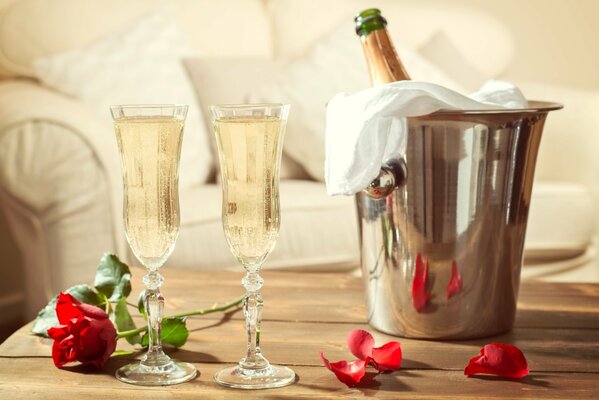 Deux verres et champagne dans un seau sur la table