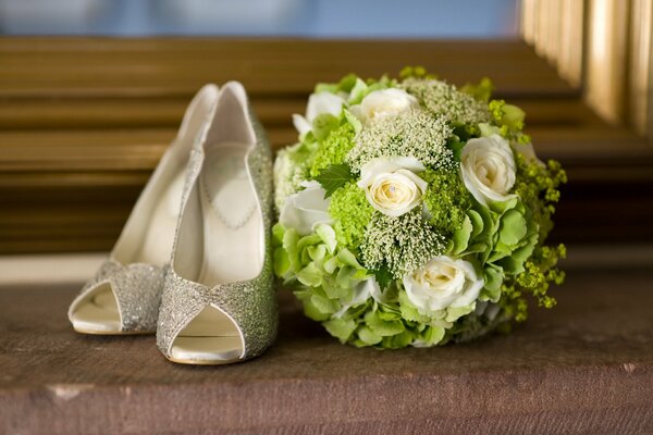 Bouquet da sposa e scarpe vicino alla finestra