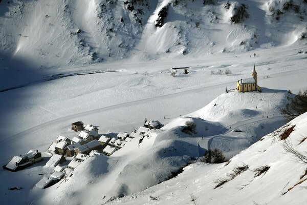 Zimowy krajobraz w górskiej wiosce z małą świątynią