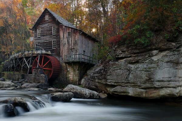 Moulin au bord de la rivière au milieu de la forêt