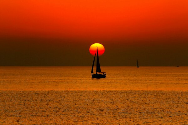 Yacht at sea in the rays of the sunset