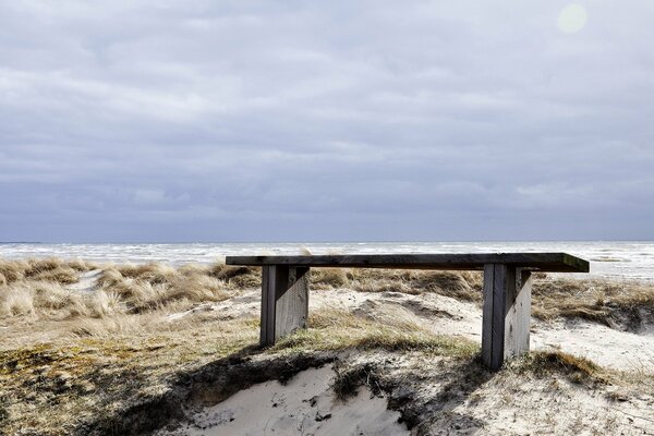 A lonely bench on a sandy beach