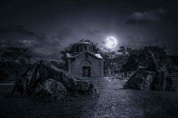 The night sky. Church under the moon. The moon illuminates the grass